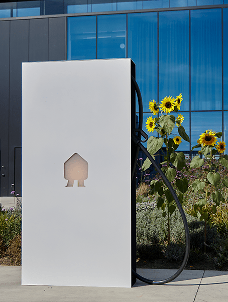 photo of a big standingdc fast charger with sun flowers