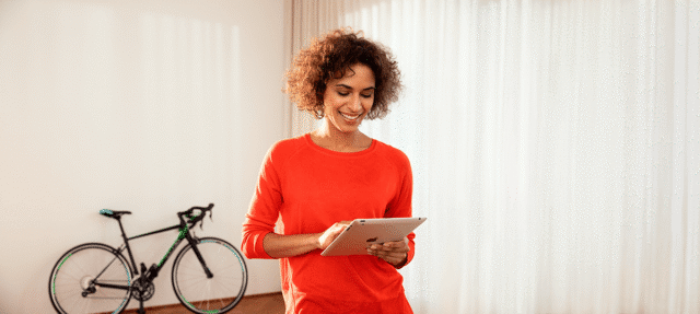 Mobile device woman on tablet home smiling